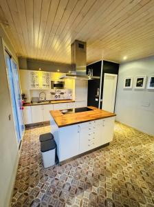 a kitchen with white cabinets and a wooden ceiling at Sevilla Family House - La casa de Marta in Montequinto +8 photos