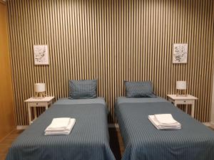 a room with two beds and two tables with towels at Casa do Negrão in Ponta Delgada