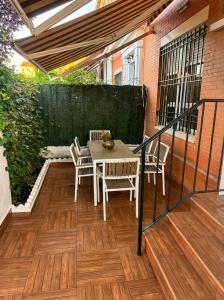 a patio with a table and chairs on a deck at Sevilla Family House - La casa de Marta in Montequinto