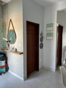 a hallway with a wooden door and a mirror at Refúgios de Itaúna in Saquarema +65 photos
