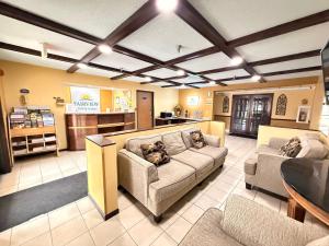 a living room with two couches and a kitchen at Fairview Inn & Suites Whitewater in Whitewater