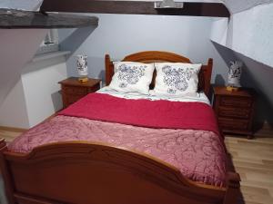 a bedroom with a large bed with red sheets and pillows at Appartement in Kesseldorf