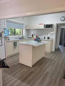 a large kitchen with white cabinets and a large island at StevieNic's Dig's in Broken Hill