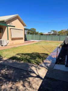 a yard with a fence and a house at StevieNic's Dig's in Broken Hill