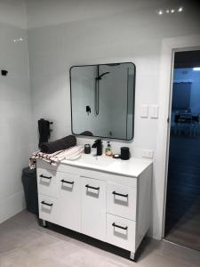 a bathroom with a white sink and a mirror at StevieNic's Dig's in Broken Hill +21 photos