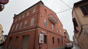 a red brick building with a car parked in front of it at Forlì City Residence in Forlì