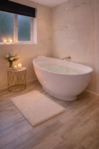 a white bath tub in a bathroom with candles at Mingarry Park in Acharacle