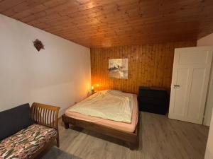 a small bedroom with a bed and a couch at Gästezimmer Stadtpark in Biel