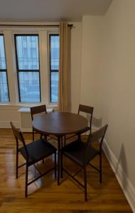 a table and chairs in a room with windows at The Broadway Escape - Private Room in Times Square in New York