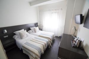 Un ou plusieurs lits dans un hébergement de l'établissement Hostal Cabo Mayor