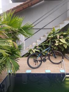 a bike parked on a wooden deck next to a swimming pool at hospedagem com passeio de quadriciclo in Guapimirim