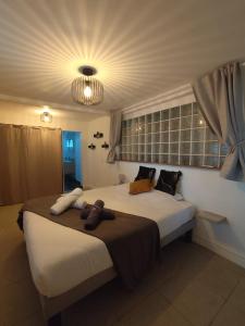 a bedroom with a large white bed with a light at Swisstropiclodges avec piscine privée in Sainte-Anne