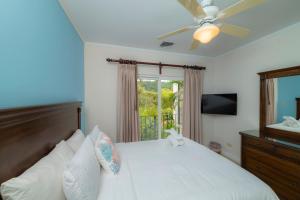 a bedroom with a bed with a ceiling fan and a window at Del Mar 3C 3 bdr Ocean View in Los Suenos in Herradura +40 photos