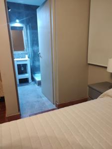 a bedroom with a bed and a room with a fireplace at Apart La Empedrada in Trapiche
