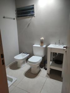 a bathroom with a toilet and a sink at Apart La Empedrada in Trapiche