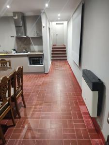 a kitchen with a red tile floor and a staircase at Apart La Empedrada in Trapiche +4 photos