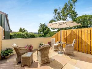 a patio with a table and chairs and an umbrella at Crich Lane Farm in Alfreton