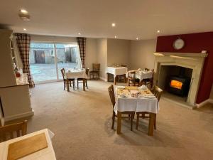 a dining room with tables and chairs and a fireplace at Crich Lane Farm in Alfreton