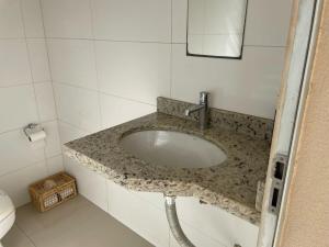 a bathroom sink with a granite counter top at Sobrado Premium - Zona Sul in Maringá +40 photos