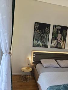 a bedroom with a bed and two pictures on the wall at Apartman Stars in Podgorica