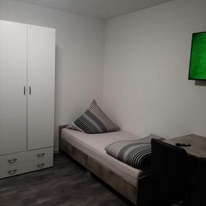 a bedroom with a bed and a cabinet and a desk at Five Rooms in Sinsheim +17 photos