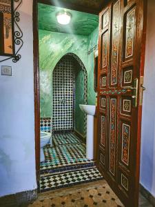 a bathroom with a toilet and a sink and a door at Riad Fés blida in Fez +53 photos
