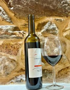 a bottle of red wine next to a glass at Cantinho D` Alice in Armamar
