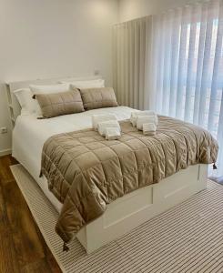 a bedroom with a large bed with two towels on it at Cantinho D` Alice in Armamar