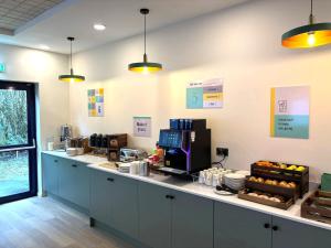 a coffee shop with a counter in a room at Garner Hotel Lincoln by IHG in Lincoln +25 photos
