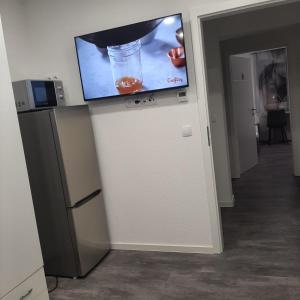 a flat screen tv sitting on top of a refrigerator at Five Rooms in Sinsheim