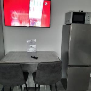 a table with chairs and a refrigerator in a room at Five Rooms in Sinsheim