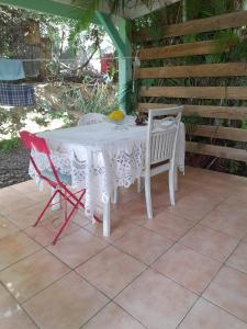 a white table and chairs on a patio at studio dans un écrin vert in Saint-Claude +3 photos