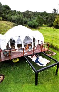 a couple of people laying in a tent in a field at Glamping Claro de Luna in Guatavita +64 photos