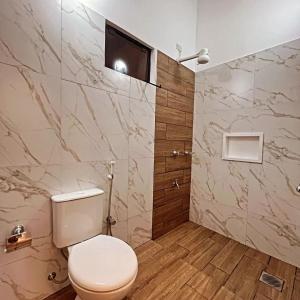 a bathroom with a toilet and a television on the wall at Tajesdelsol in Luque
