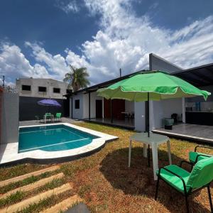 a patio with an umbrella and a swimming pool at Tajesdelsol in Luque