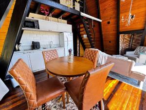 a kitchen and dining room with a table and chairs at Romantic nature retreat | Hot tub and fireplace in São Pedro de Alcântara