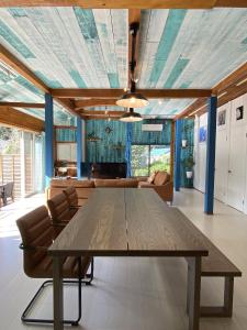 a dining room with a table and a couch at Aqua Beach House Sotoura - 1min walk to Sotoura Beach! in Shimoda