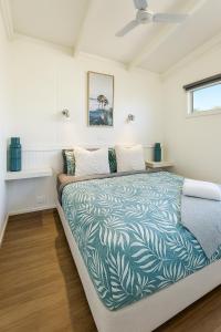 a bedroom with a bed with a green and white comforter at Kanasta Caravan Park in Rye