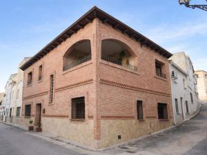 a red brick building with a balcony on a street at Casa Rural Caraca in Driebes