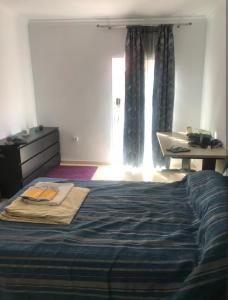 a bedroom with a bed and a desk and a window at Enjoy Sevilla in La Rinconada