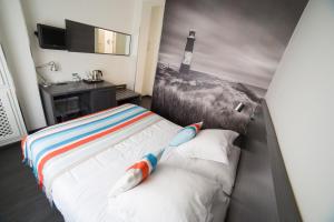 - une chambre avec un lit orné d'une peinture de phare dans l'établissement Hostal Cabo Mayor, à Santander