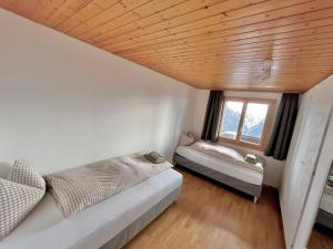 a bedroom with a bed and a window at Chalet Talblick in Riederalp