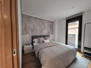 a bedroom with a large white bed and a window at Mercurio Blanco-Zona Catedral in León