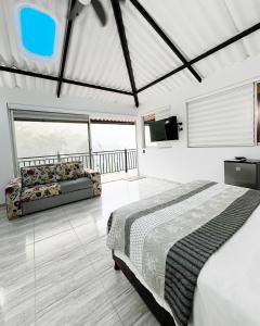 a bedroom with a bed and a couch and a television at Hotel cabañas sol paz DF in La Vega +94 photos