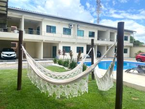 a hammock in front of a building at Cacao's Guaibim Residence in Valença