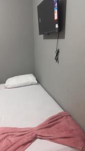 a bed with a red blanket on it in a room at Pousada Bem estar in Divinópolis