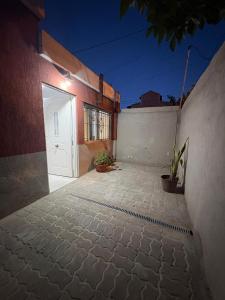 a driveway with a white door and a building at Dpto Céntrico con Asador in Chilecito