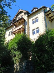 a large white building on top of a hill at Ferienwohnung Stadtblick Königstein in Königstein an der Elbe