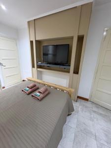 a bedroom with a bed with two pillows and a tv at Dpto Céntrico con Asador in Chilecito