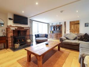 a living room with a table and a fireplace at Bwthyn Y Bugail Shepherd's Cottage in Oswestry